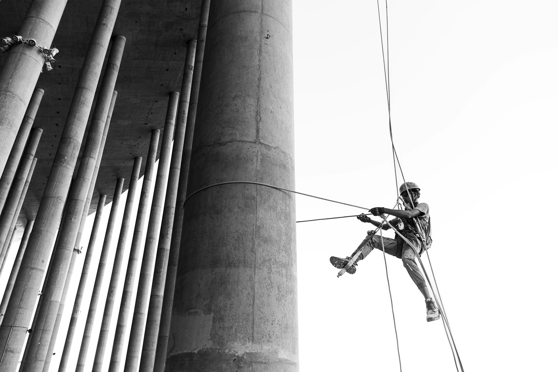 Man rappels down a tall concrete structure